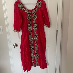 A red kurti with embroidery in the middle and on the sleeves